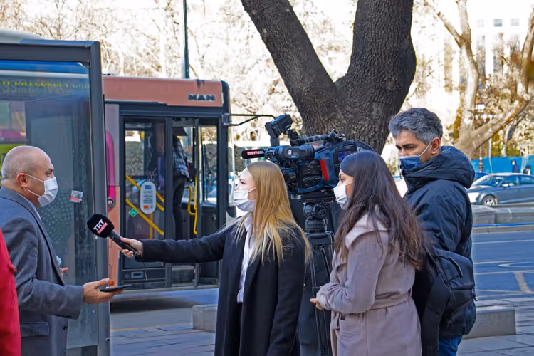Reporter recording a comment from an interviewee on location