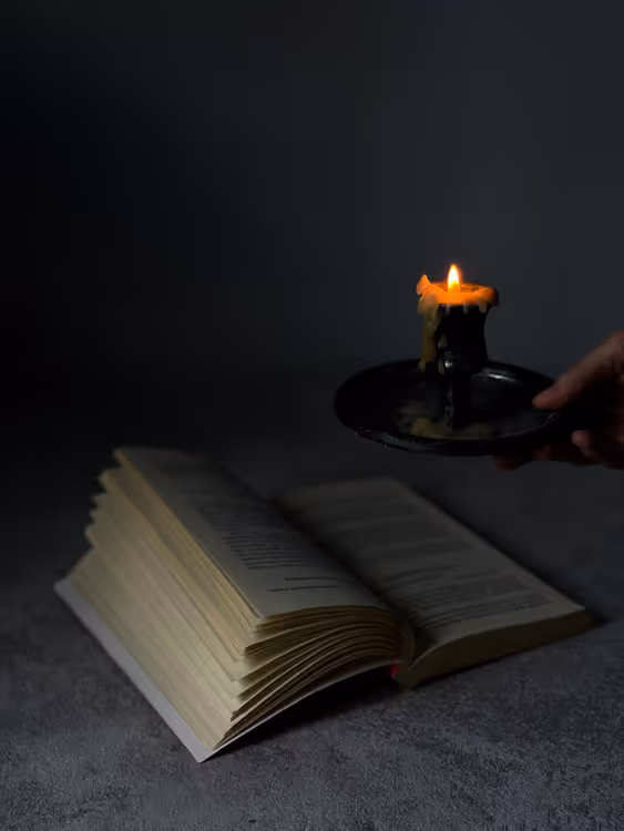 Livre ouvert à la bougie comme symbole d'un système magique en fantasy