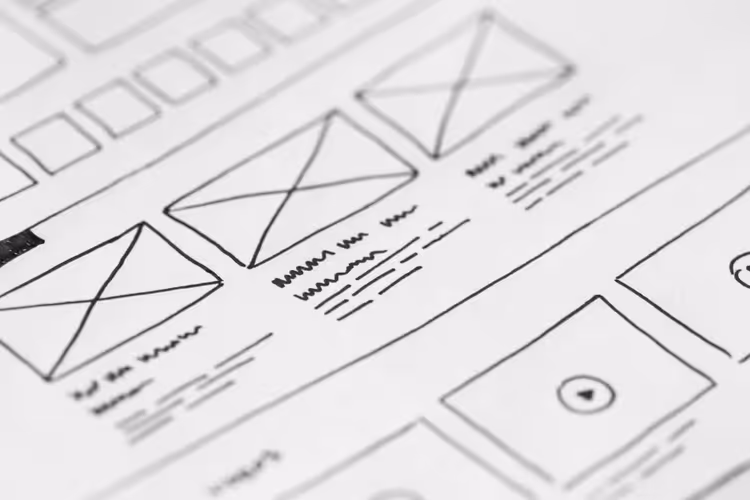 Croquis de structure de site web sur papier à côté d'un ordinateur portable