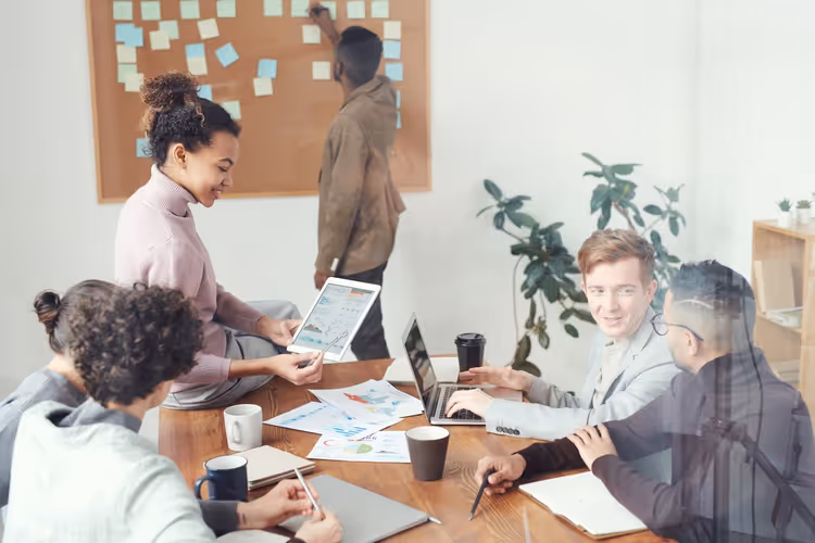 Équipe discutant de contenu autour d'une table - les relations avec les éditeurs de sites se construisent sur la confiance