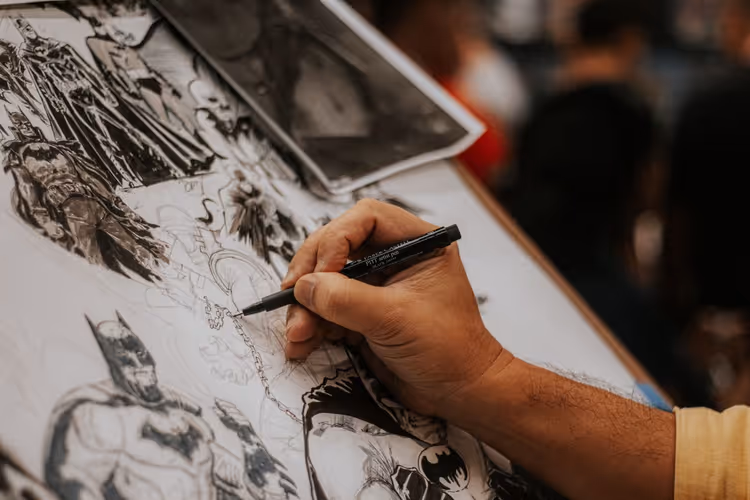 Artysta komiksowy szczegółowo rysuje postacie na kreatywnym spotkaniu