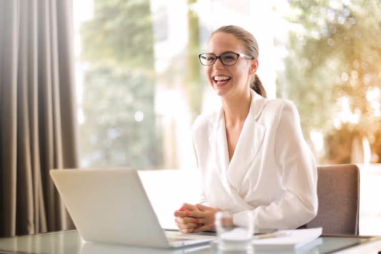 Bizneswoman w okularach analizuje dane z ankiet klientów na laptopie w jasnym biurze