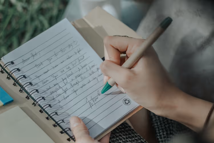 Woman taking notes in a notebook at a desk