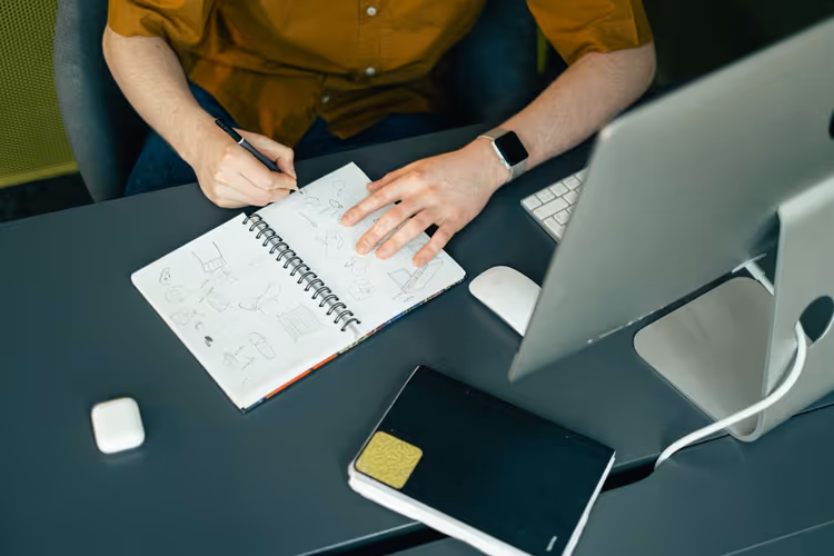 Designer workspace with a computer and cover sketches
