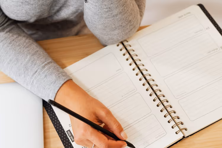 Writer working on a manuscript draft in a notebook