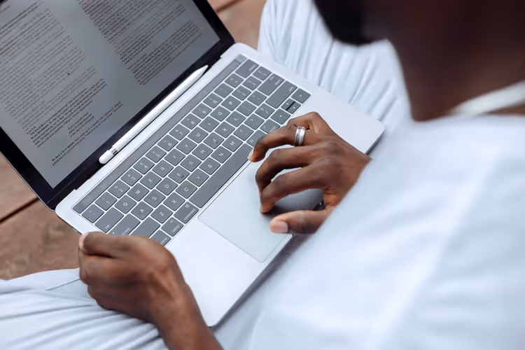 Person reviewing website documents and metrics on a laptop before submitting an application