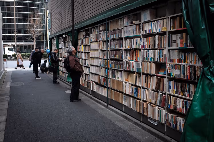 Visitors browsing books at outdoor shelves