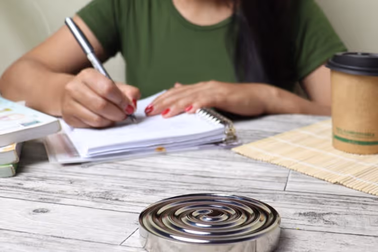 Person taking notes in a notebook in soft daylight