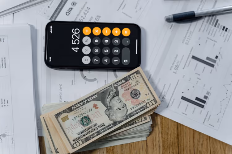 Calculator, cash and printed report on an author's desk