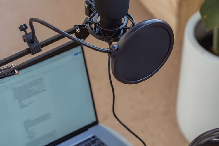 Micro sur pied à côté d'un ordinateur portable dans un studio d'enregistrement de podcast