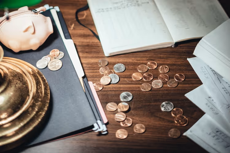 Coins and documents on a wooden table as a symbol of calculating an author's income