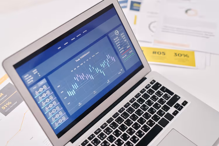 Ordinateur portable avec graphiques et rapports imprimés sur le bureau d'un éditeur