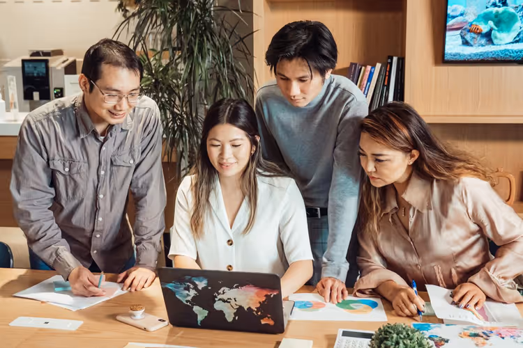 Team discussing materials at a laptop in a meeting room